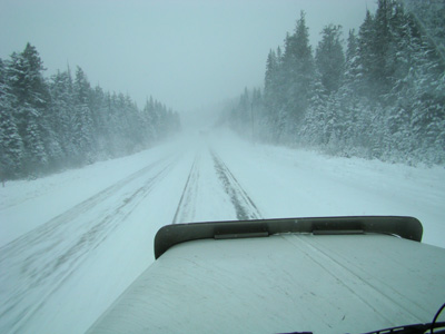 following a loaded logging truck during a snow storm in Blue River BC Canada